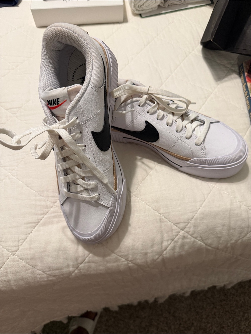 Nike White Low-Top Sneakers with Black Swoosh and Gold Trim